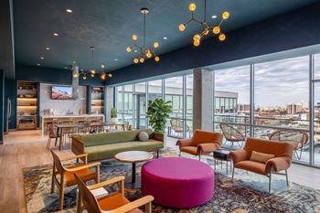 14Th floor resident clubroom with chef's kitchen, open seating area with fireplace, serving counter and dining area